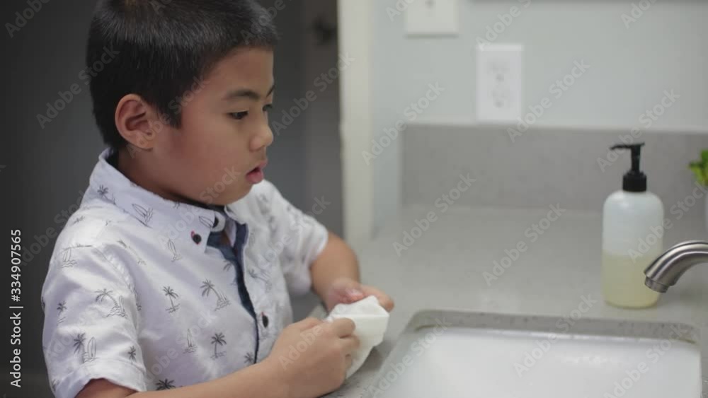 Young school age boy sneezing into tissue to prevent spread of germs, virus, flu, coronavirus. Slow motion Young school age boy sneezing into tissue to prevent spread of germs, virus, flu, coronavirus. Slow motion