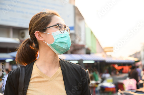 Woman wearing surgical mask for protect bad air pollution or virus in pandemic situations. Conceptual of urban lifestyle and using mask for avoid bad environment.