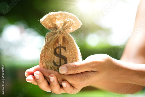 Hand of a woman carrying a purse money .concept saving money and investment concept