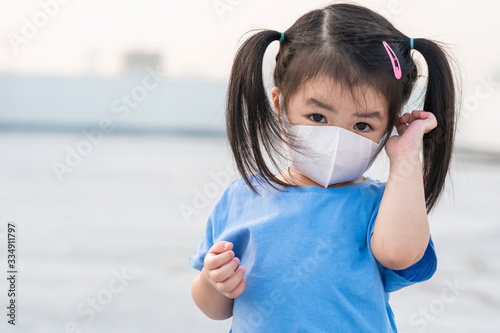 A little girl wearing mask for prevent the spread of the Covid-19, Covic 19 virus protection concept in Thailand.. photo