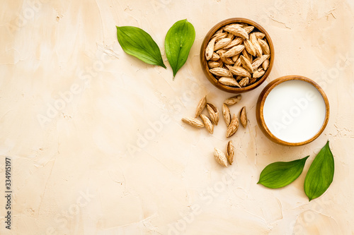 Wallpaper Mural Alternative milk made from almond. Drink near unpeeled on beige table top-down copy space Torontodigital.ca