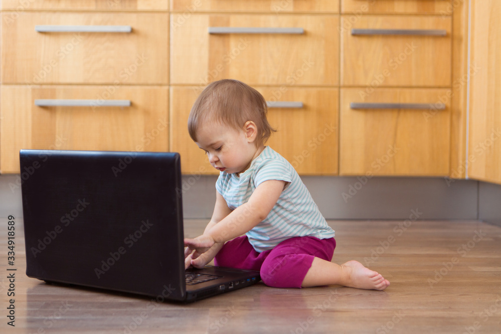 a small child plays on the computer. The child Prodigy learns the techniques of business Planning, home work, quarantine, self-isolation, protection from coronavirus, virus, home education, distance w a small child plays on the computer. The child Prodigy learns the techniques of business Planning, home work, quarantine, self-isolation, protection from coronavirus, virus, home education, distance w