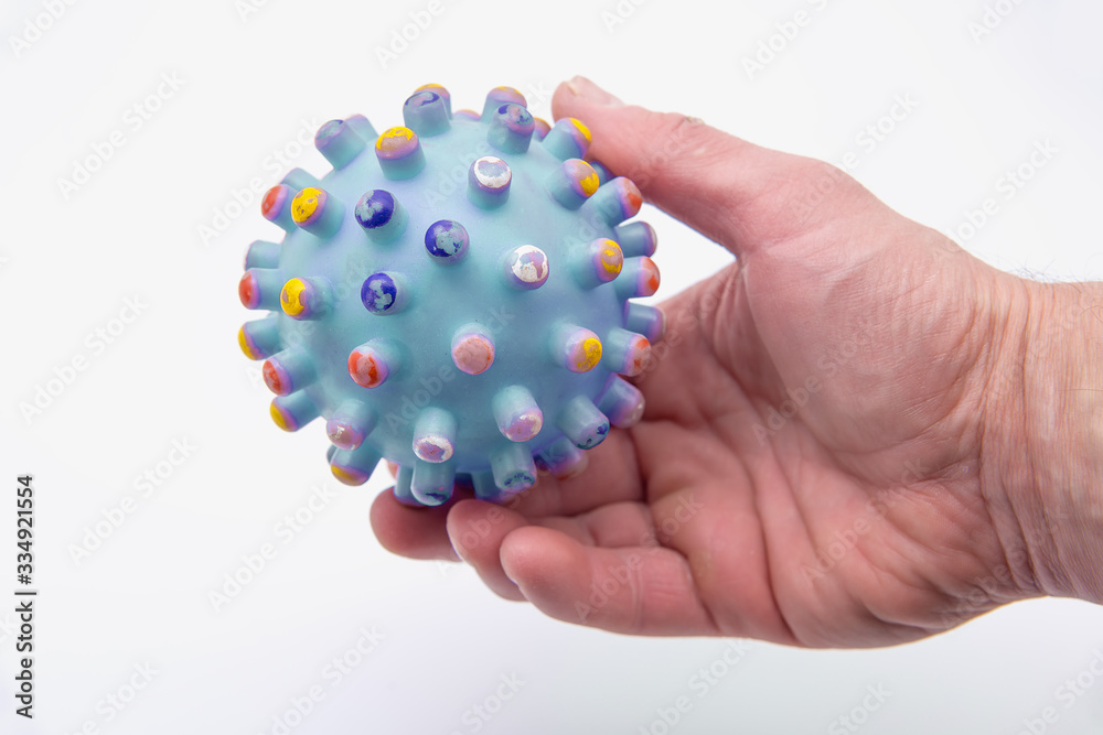 The human hand holds the SARS-CoV-2 virus. White background. The concept of the COVID-19 pandemic.
