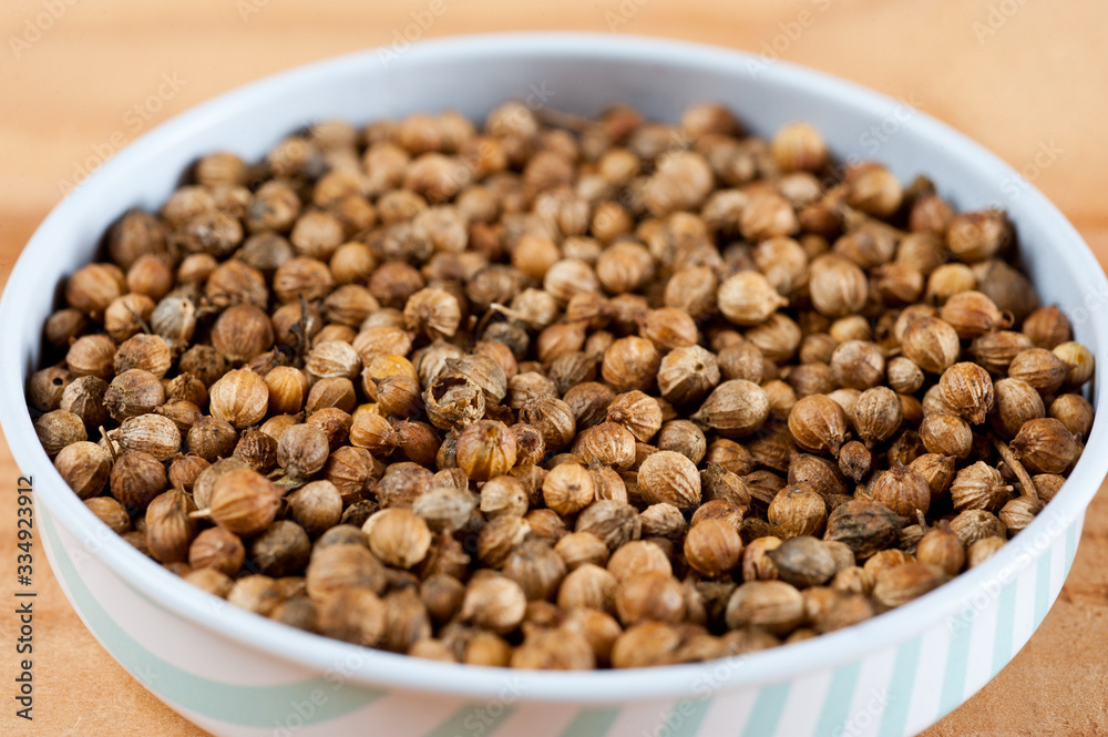 Coriander grains shot large on a wooden background. Background for spices and cuisine. Coriander grains shot large on a wooden background. Background for spices and cuisine.
