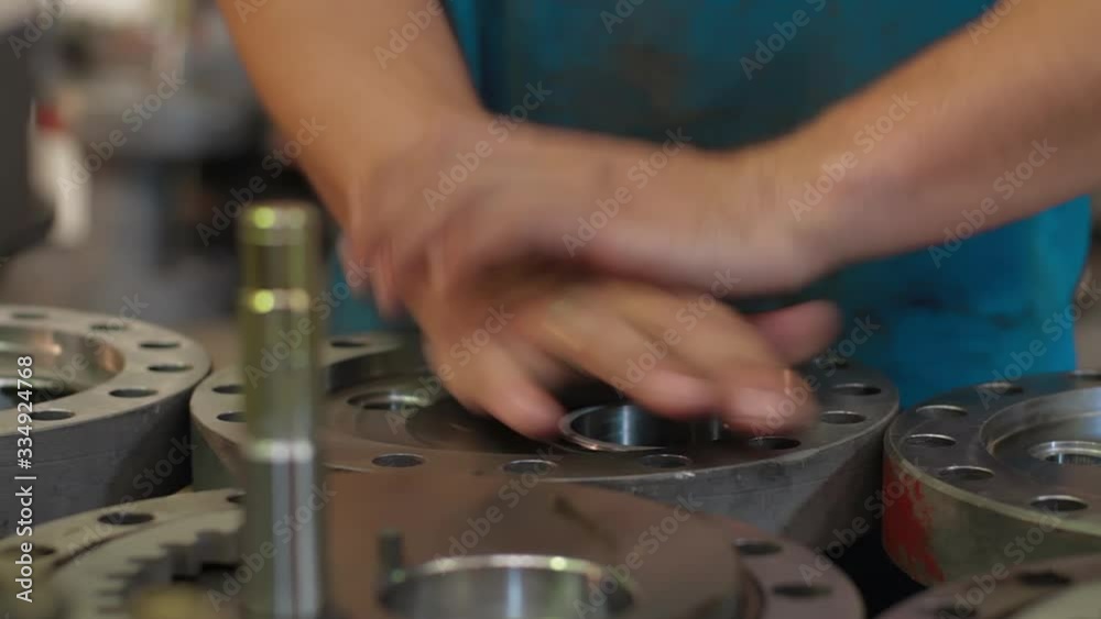 Engineer checks quality Parts of wellhead fittings and butterfly valves. Oil and Gas Wellhead tree equipment production plant. Equipment for wellhead conncetion of oil and gas wells.