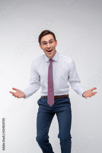 Young, handsome man in a white shirt with a tie on a white background in studio