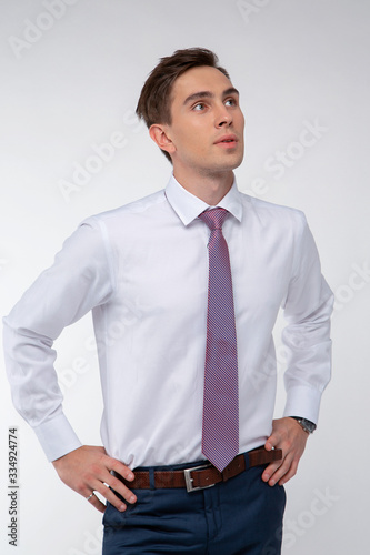 Young, handsome man in a white shirt with a tie on a white background in studio