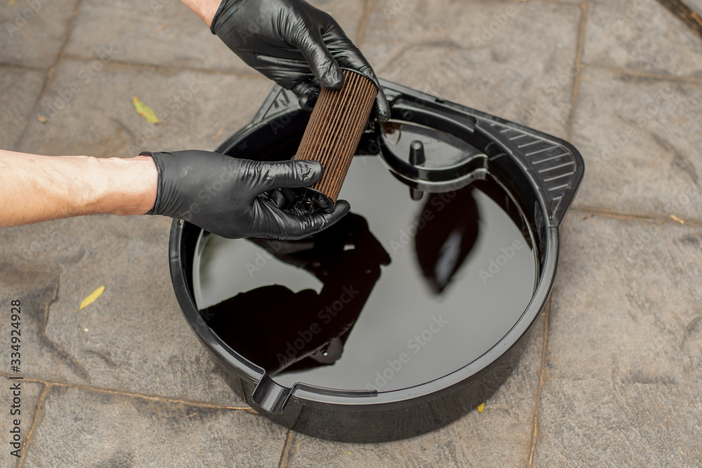 Used drained motor oil in a black tray and used oil filter. DIY change