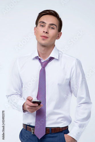 Young, handsome man in a white shirt with a tie on a white background in studio
