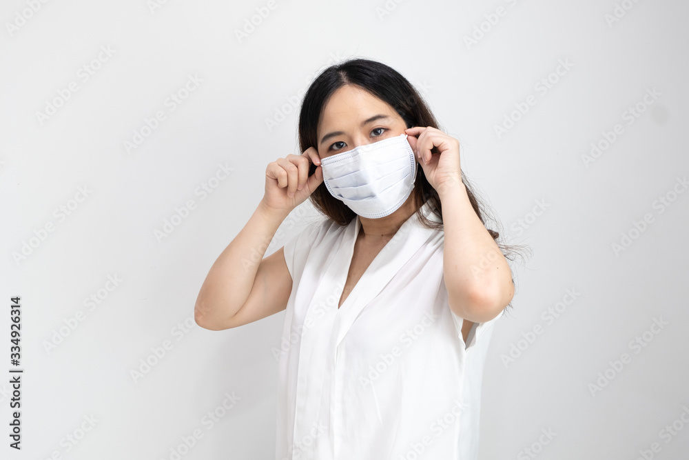 Close up of Asian girl wearing protective mask, with copy space, isolated on white background. Concept of Coronavirus COVID-19 reducing of risk of spreading the infection Close up of Asian girl wearing protective mask, with copy space, isolated on white background. Concept of Coronavirus COVID-19 reducing of risk of spreading the infection