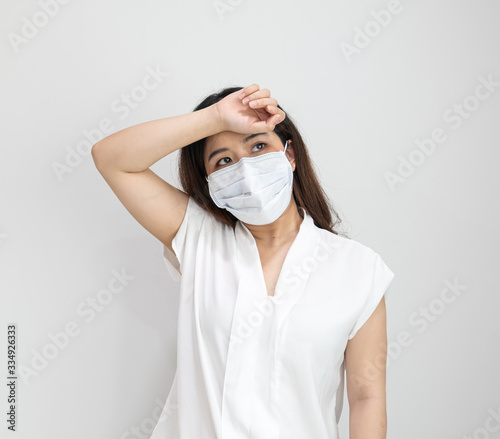 Close up of Asian girl wearing protective mask have a fever, a cough or difficulty breathing isolated on white.Concept of Coronavirus COVID-19, Coronavirus disease pandemic.