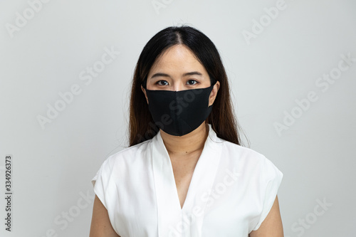 Close up of Asian girl wearing protective mask, with copy space, isolated on white background. Concept of Coronavirus COVID-19, Coronavirus disease pandemic.