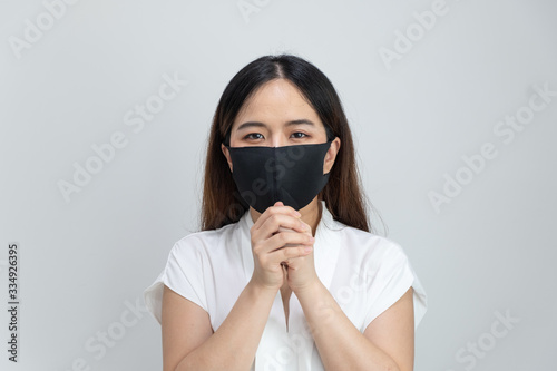 Close up of Asian girl wearing protective mask begging with copy space, isolated on white background. Concept of Coronavirus COVID-19, Coronavirus disease pandemic.