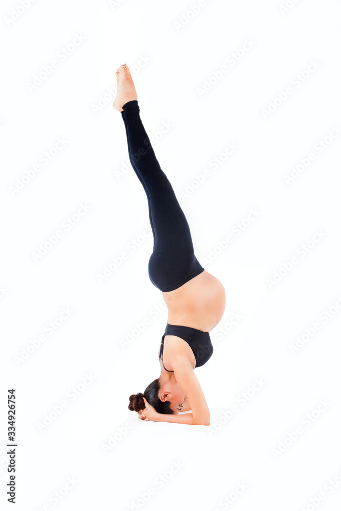 Schwangere Frau macht einen Kopfstand, Yoga Übung Schwangere Frau macht einen Kopfstand, Yoga Übung