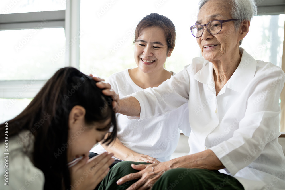 Happy smiling asian senior woman is stroking her child girl head, welcoming her family,loving daughter with her mother comes to visit her grandmother at home,pay respect to the elderly,Thai culture Happy smiling asian senior woman is stroking her child girl head, welcoming her family,loving daughter with her mother comes to visit her grandmother at home,pay respect to the elderly,Thai culture