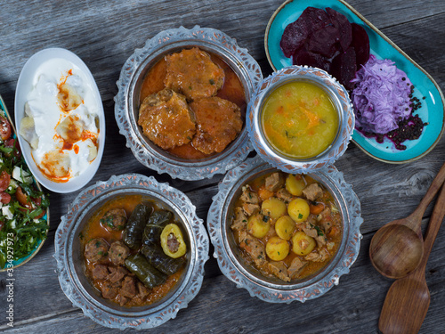 Eid Mubarak Traditional Ramadan Iftar dinner. Assorted tasty food in authentic rustic dishes on wooden table background. photo