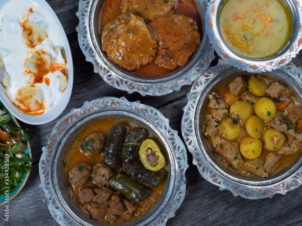 Eid Mubarak Traditional Ramadan Iftar dinner. Assorted tasty food in authentic rustic dishes on wooden table background. Eid Mubarak Traditional Ramadan Iftar dinner. Assorted tasty food in authentic rustic dishes on wooden table background.