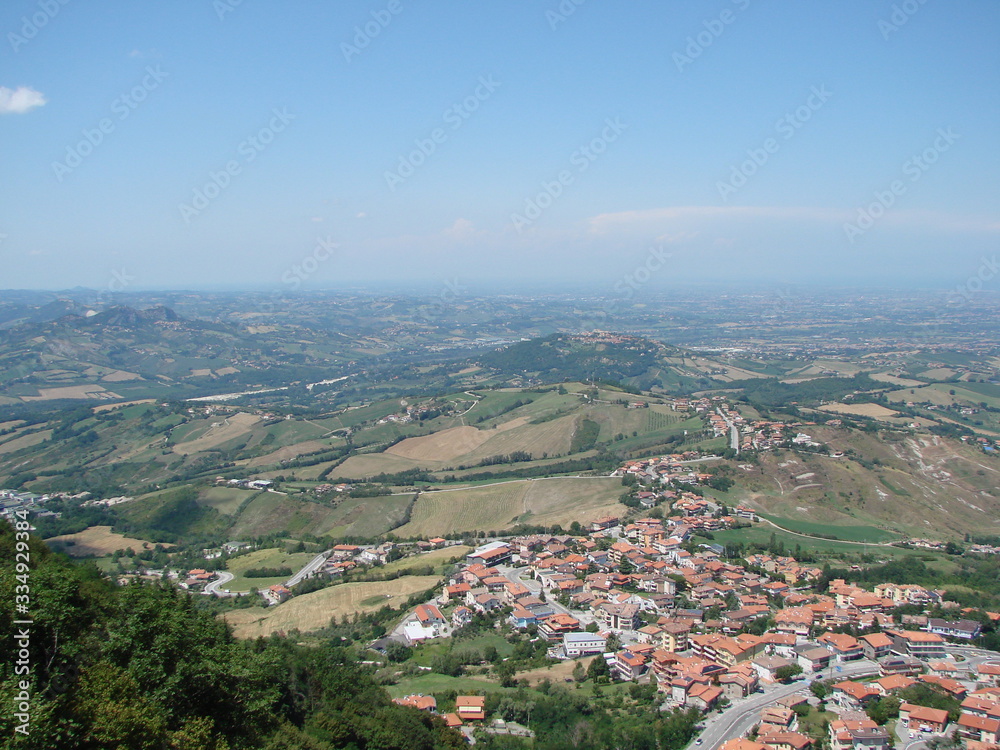 Top view of a small Central European country under a summer midday blue sky against the backdrop of the Adriatic in a foggy horizon.