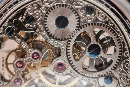 precise gears of a pocket watch, six rubies are seen