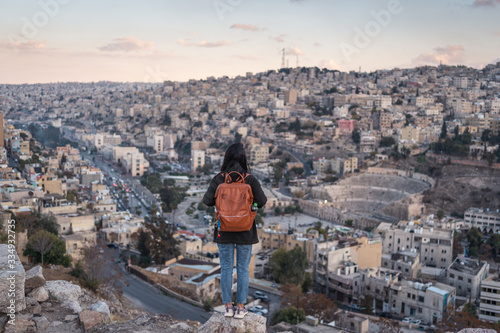 Cuadro en lienzo A woman traveller with backpack standing on top of the mountain in Amman city in