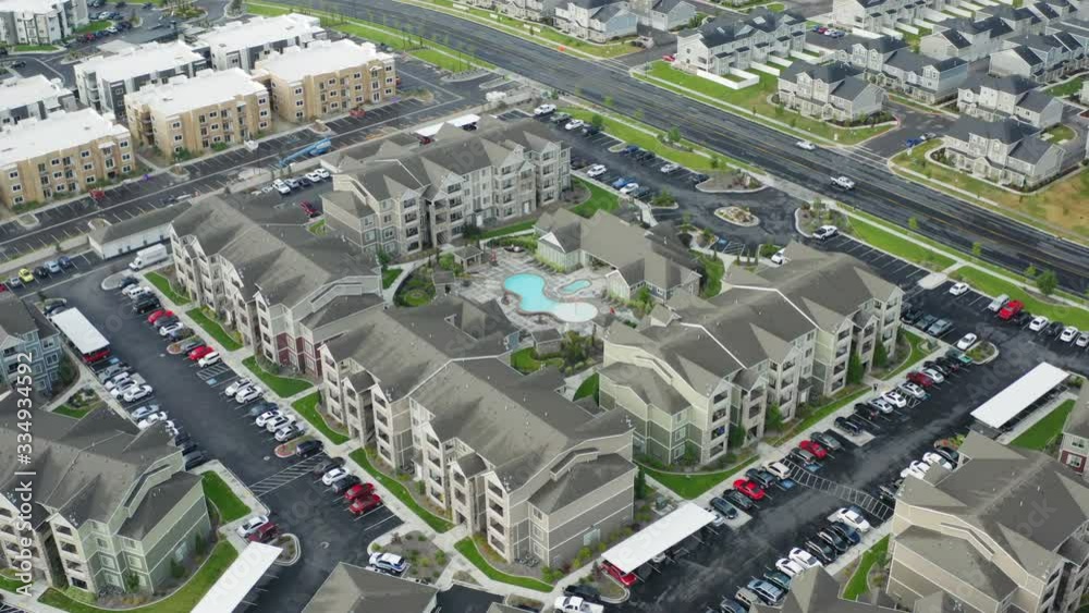 High aerial view of large apartment complex with pool in slow rotation
