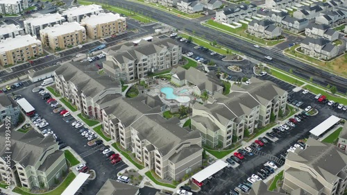 High aerial view of large apartment complex with pool in slow rotation