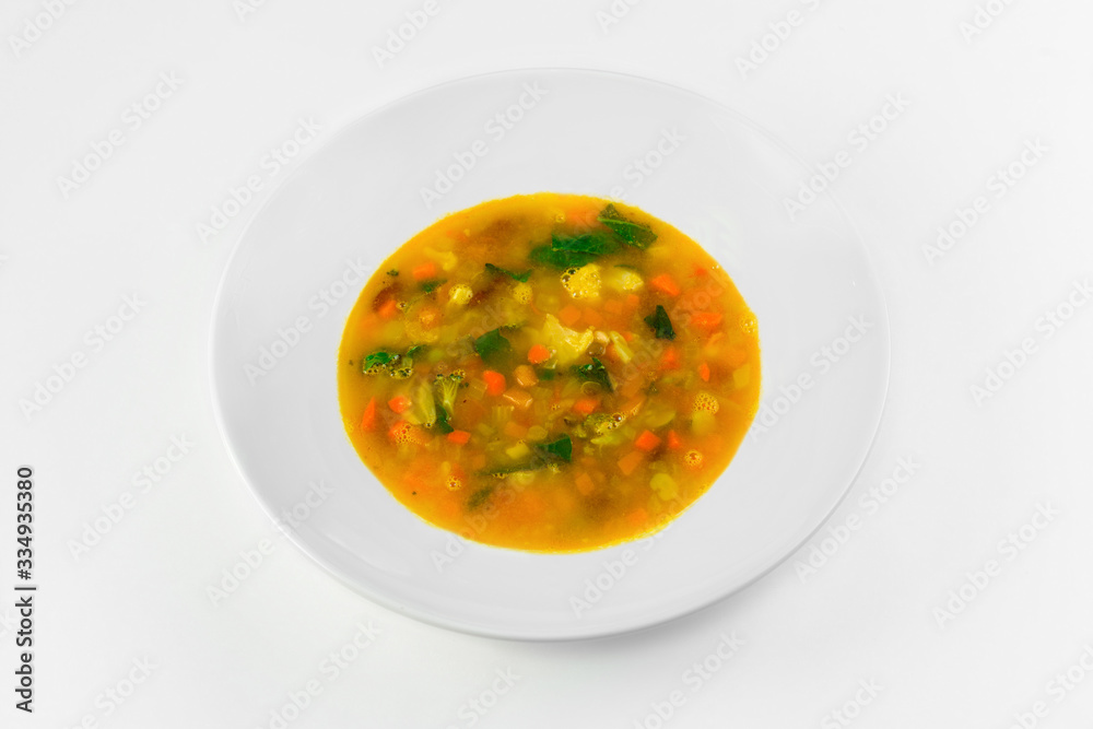 Vegetable soup in a plate on a white background. The view from the top