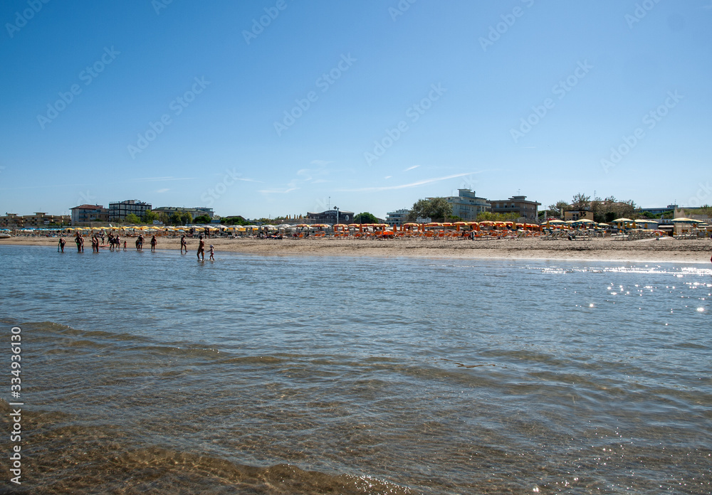  People are resting on a sunny day at the beach in Cesenatico, Italy