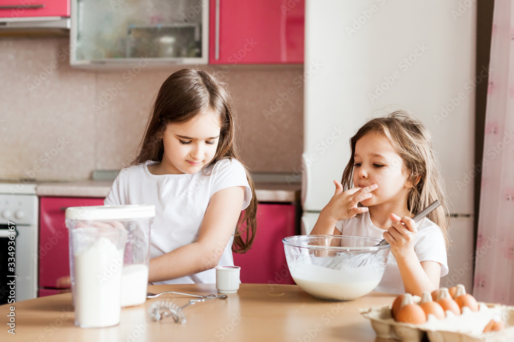 Sisters prepare Breakfast, pastries, mix flour, milk, eggs, pancakes in a bowl, children help mother, family Breakfast, cooking Sisters prepare Breakfast, pastries, mix flour, milk, eggs, pancakes in a bowl, children help mother, family Breakfast, cooking