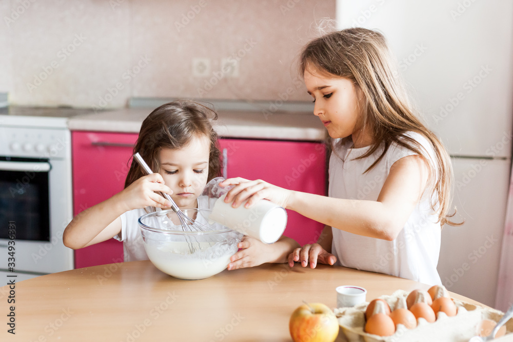 Sisters prepare Breakfast, pastries, mix flour, milk, eggs, pancakes in a bowl, children help mother, family Breakfast, cooking Sisters prepare Breakfast, pastries, mix flour, milk, eggs, pancakes in a bowl, children help mother, family Breakfast, cooking