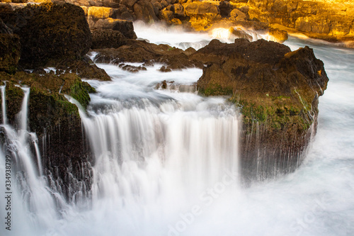 the waves of the ocean that hit the cliff