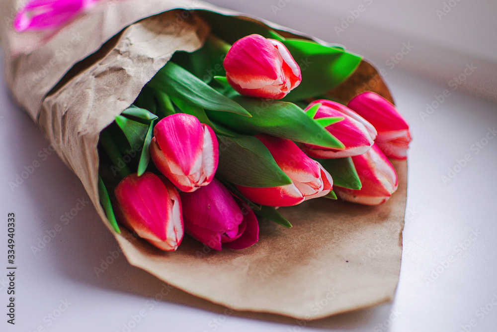 Beautiful fresh morning pink bouquet of tulips on the window. Fragrant smell of fresh spring tulips in a paper wrapper Beautiful fresh morning pink bouquet of tulips on the window. Fragrant smell of fresh spring tulips in a paper wrapper