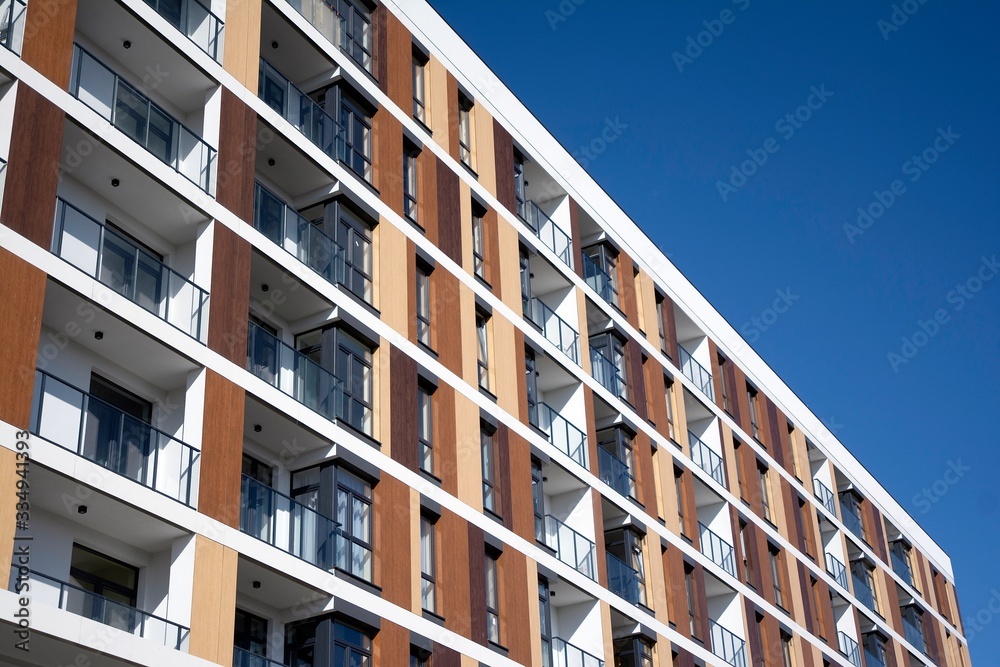 Exterior of new apartment buildings on a blue cloudy sky background. No people. Real estate business concept. Exterior of new apartment buildings on a blue cloudy sky background. No people. Real estate business concept.
