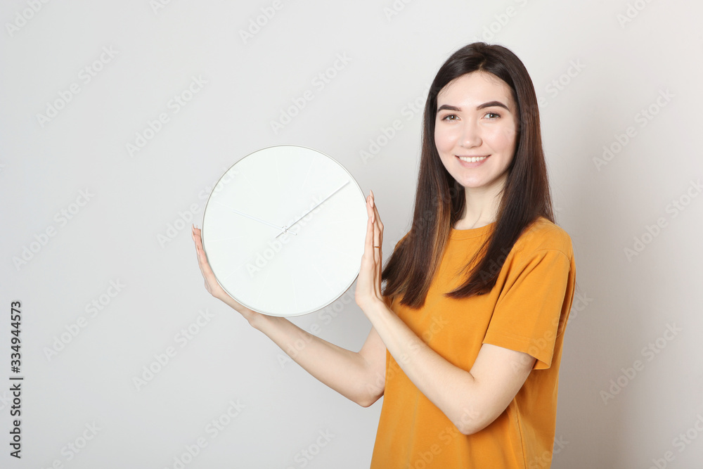 Girl holds a mechanical clock on a colored background Girl holds a mechanical clock on a colored background