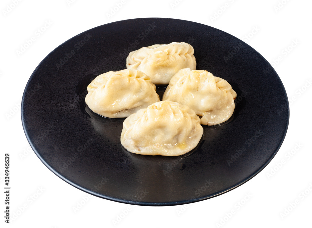 cooked Manti on black plate isolated on white