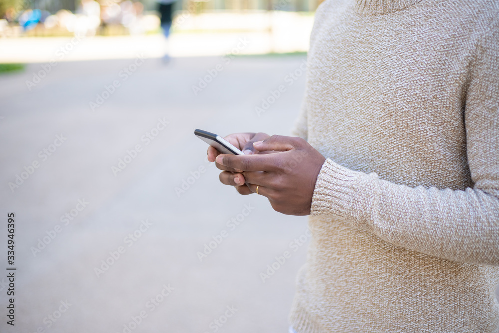 Cropped view of woman texting on smartphone. Closeup view of female hands using modern phone on street. Technology and phone addiction concept Cropped view of woman texting on smartphone. Closeup view of female hands using modern phone on street. Technology and phone addiction concept