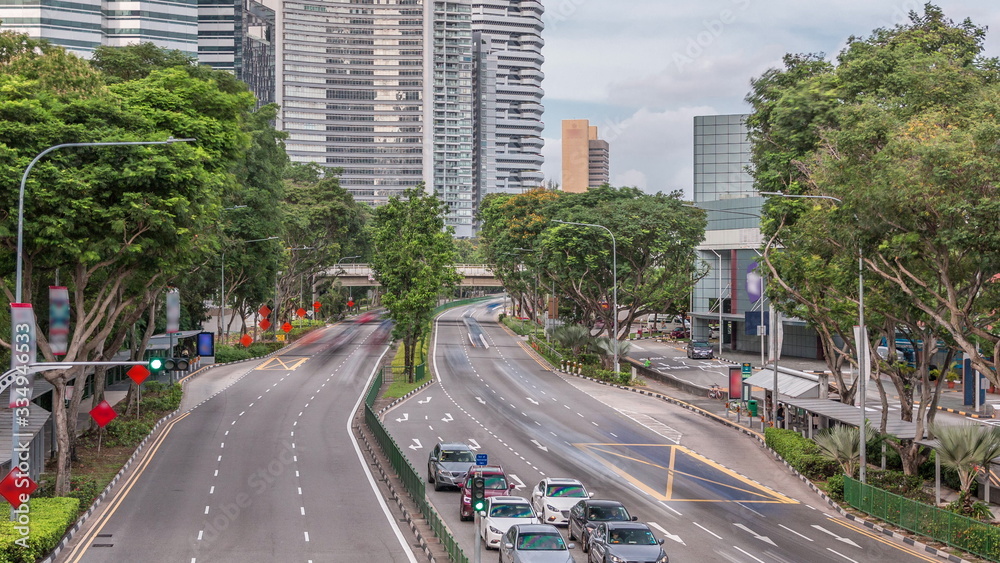 Obraz premium Traffic with cars on a street and urban scene in the central district of Singapore timelapse