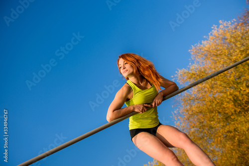 Young fit female training do exercises outdoor on sky fackground