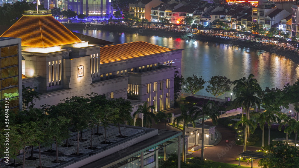 Parliament House in downtown Singapore aerial night timelapse and boat quay in the background.