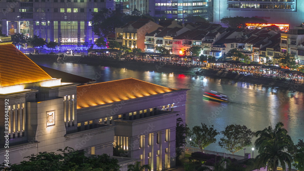 Parliament House in downtown Singapore aerial night timelapse and boat quay in the background.