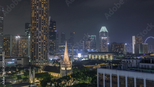 Singapore skyline with St. Andrew's Cathedral aerial night timelapse hyperlapse. photo