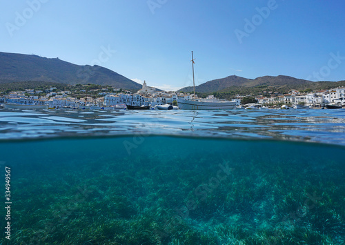 Spain coast of Cadaques village with boats and seagrass underwater, split view over and under water surface, Mediterranean sea, Costa Brava, Catalonia photo