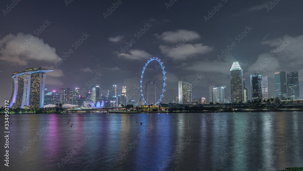 Naklejka premium Downtown skyline of Singapore as viewed from across the water from The Garden East night timelapse. Singapore.