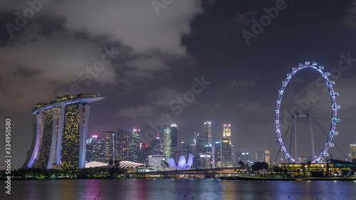 Downtown skyline of Singapore as viewed from across the water from The Garden East night timelapse hyperlapse. Singapore. © neiezhmakov