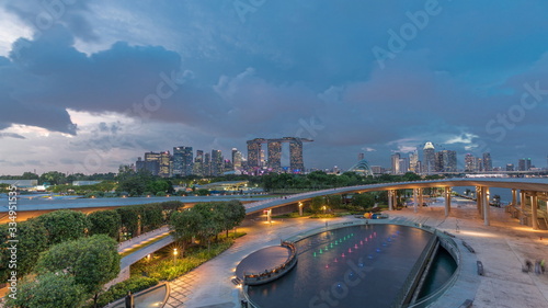 Aerial view after sunset with Singapore city skyline view from Marina barrage garden day to night timelapse.
