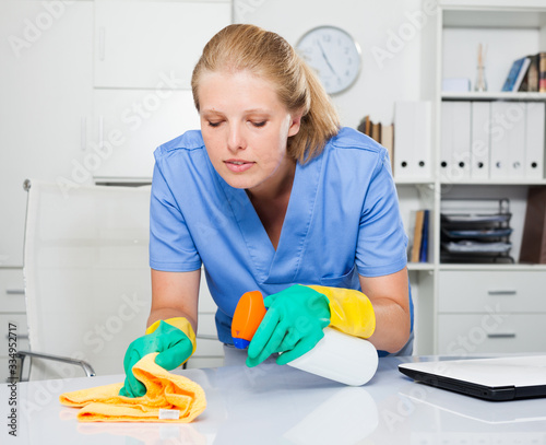 Professional cleaner cleaning desk
