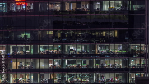 Modern office building with big windows at night timelapse, in windows light shines © neiezhmakov
