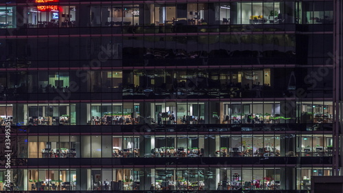 Modern office building with big windows at night timelapse, in windows light shines