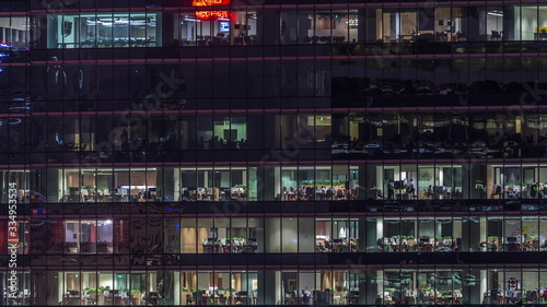 Modern office building with big windows at night timelapse, in windows light shines © neiezhmakov