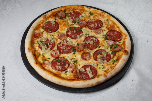 Italian pizza on gray plates on a white plate with spices and seasonings vegetables and meat.